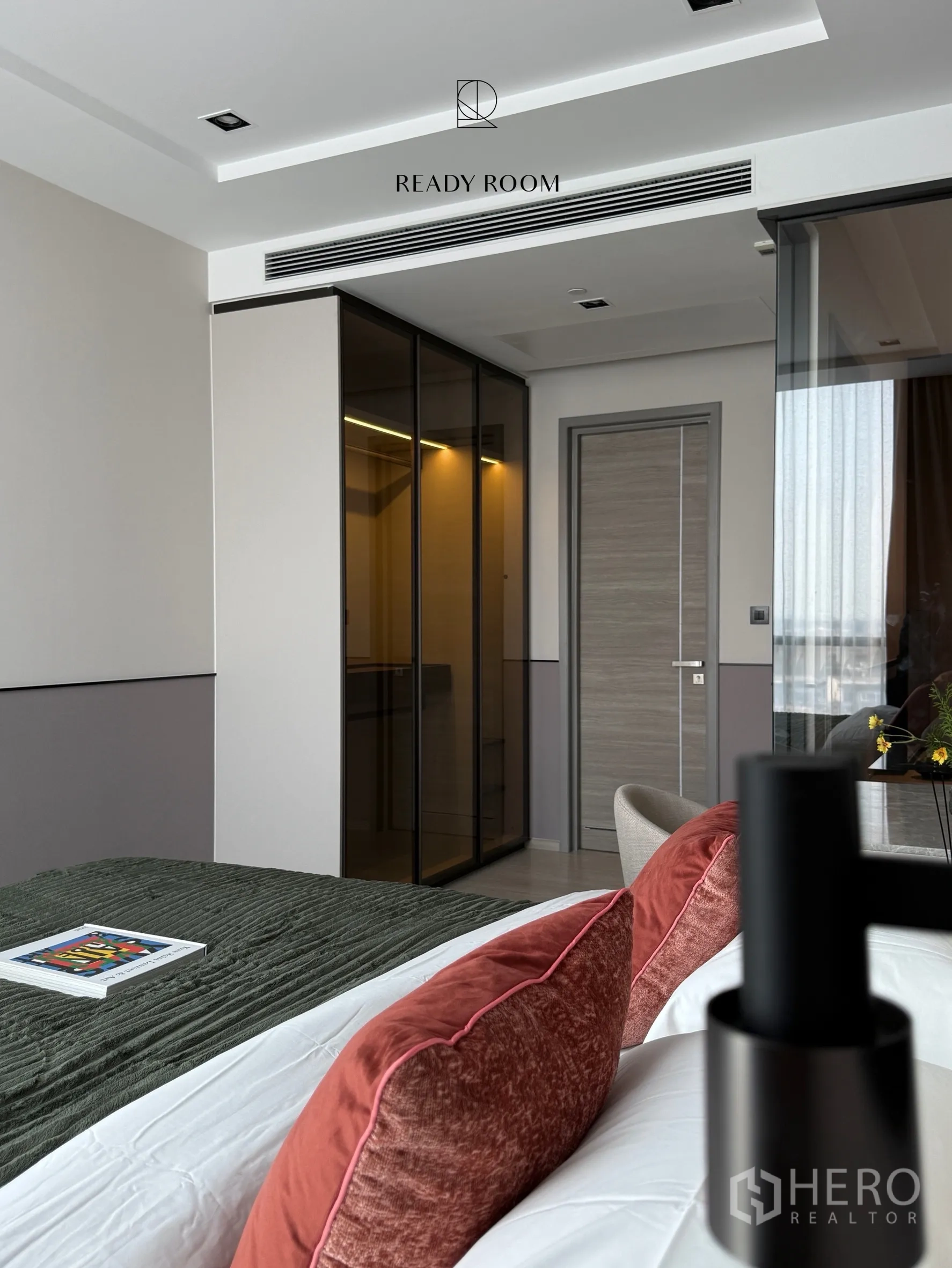Condominium for rent in Khlong Toei, Bangkok - Bedroom corner with glass wardrobe, bedside lighting, and door.