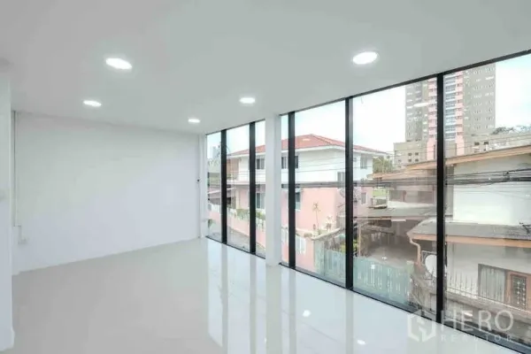Standalone for rent or sale in Bang Na, Bangkok - Upper-floor workspace with full-height windows and LED downlights.