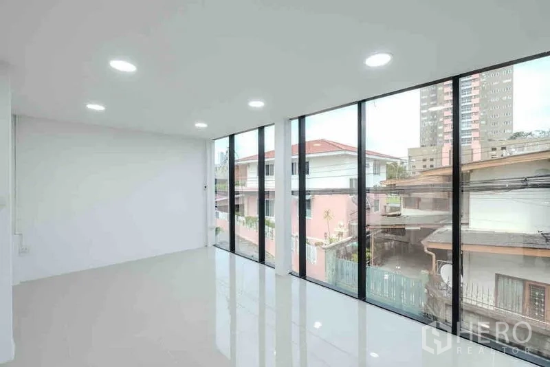 Standalone for rent or sale in Bang Na, Bangkok - Upper-floor workspace with full-height windows and LED downlights.