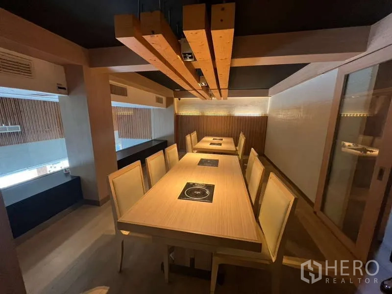 Shophouse for rent or sale in Khlong Toei, Bangkok - Industrial-style dining hall with rows of metal tables and ceiling ducting.
