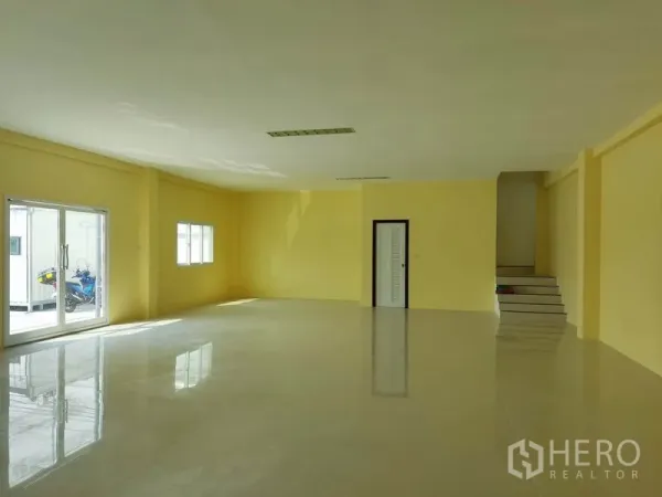 Factory for sale in Mueang Samut Sakhon, Samut Sakhon - Bright office or showroom with glossy tile floors, yellow walls and sliding glass doors.