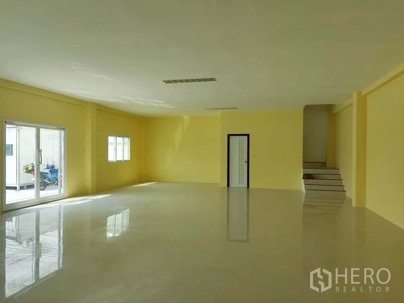 Factory for sale in Mueang Samut Sakhon, Samut Sakhon - Bright office or showroom with glossy tile floors, yellow walls and sliding glass doors.
