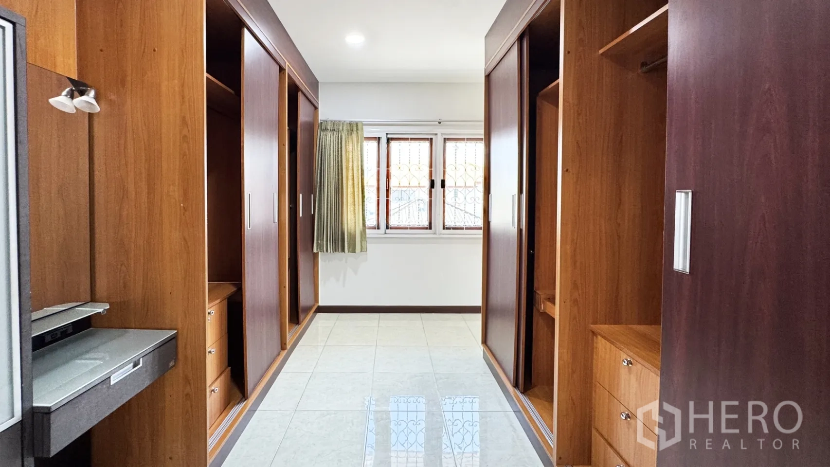 บ้านเดี่ยว for rent in Suan Luang, Bangkok - โถงห้องแต่งตัวพร้อมตู้เสื้อผ้าบิวท์อินไม้ทั้งสองฝั่งและหน้าต่างรับแสง