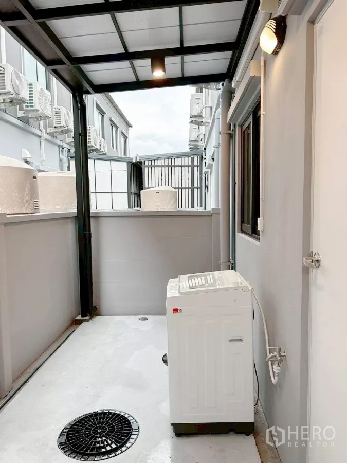 Townhouse for rent in Bang Phli, Samut Prakan - Roofed rear utility area with washing machine and drainage.