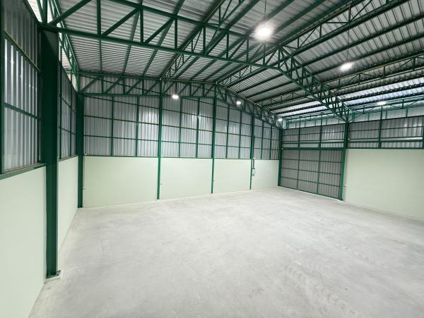 Warehouse for rent in Lat Krabang, Bangkok - Clear-span warehouse floor with corrugated metal walls and bright LED lighting.