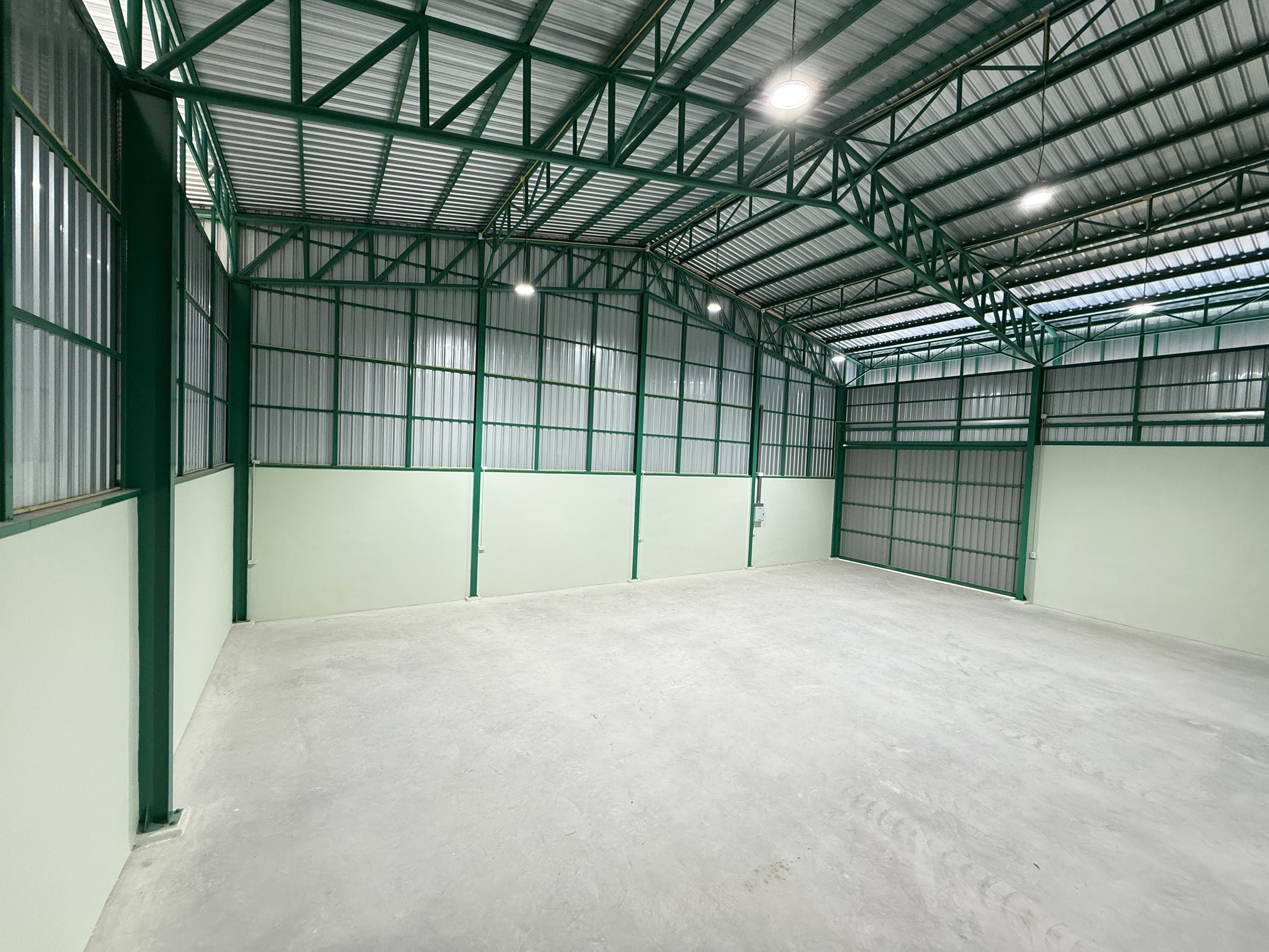 Warehouse for rent in Lat Krabang, Bangkok - Clear-span warehouse floor with corrugated metal walls and bright LED lighting.