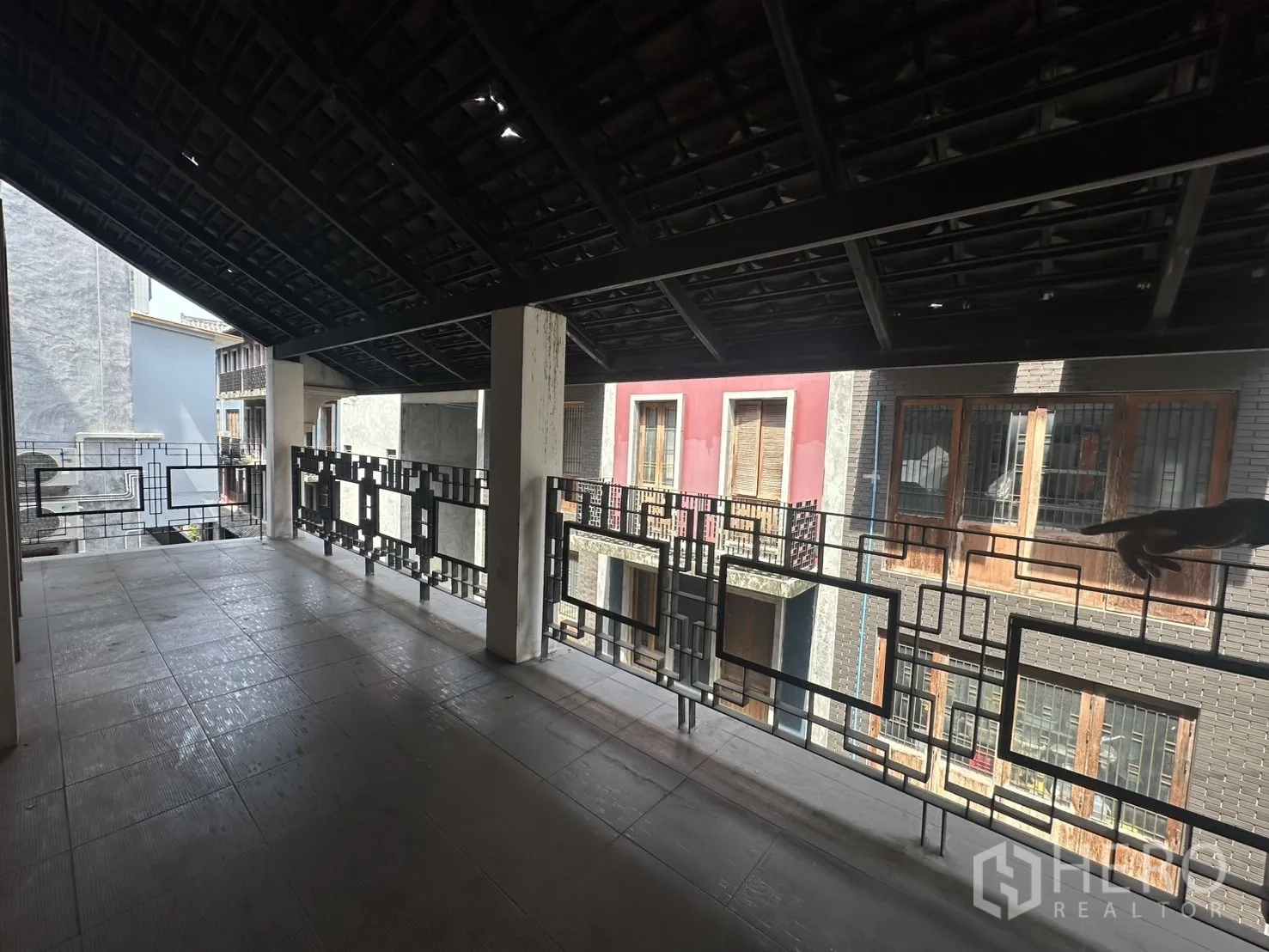 Home Office for rent in Pathum Wan, Bangkok - Wide shaded veranda under a pitched roof overlooking neighboring townhouses.