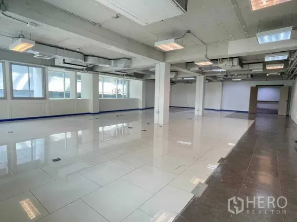 办公空间 出租在Ratchathewi, Bangkok - 开放式办公室，亮面瓷砖地面，外露管道天花、立柱与大窗户。