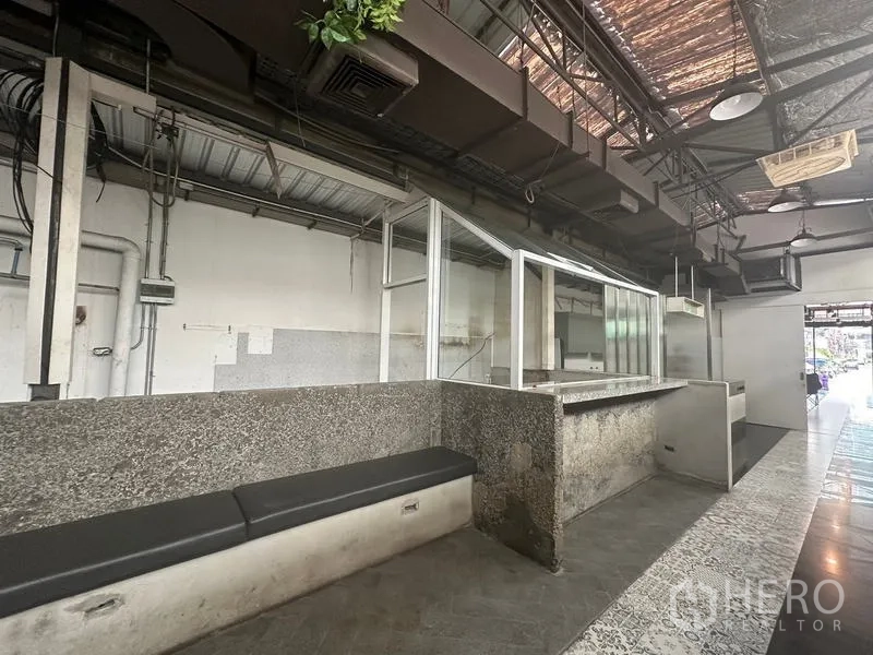 Retail Space for rent in Bang Rak, Bangkok - Alternative view of granite seating and retail counter facing the entrance and tiled floor.