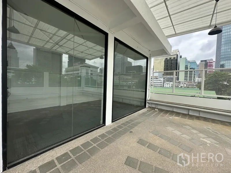 Retail Space for rent in Bang Rak, Bangkok - Glass storefront with sliding doors opening to the terrace and a skyline backdrop.