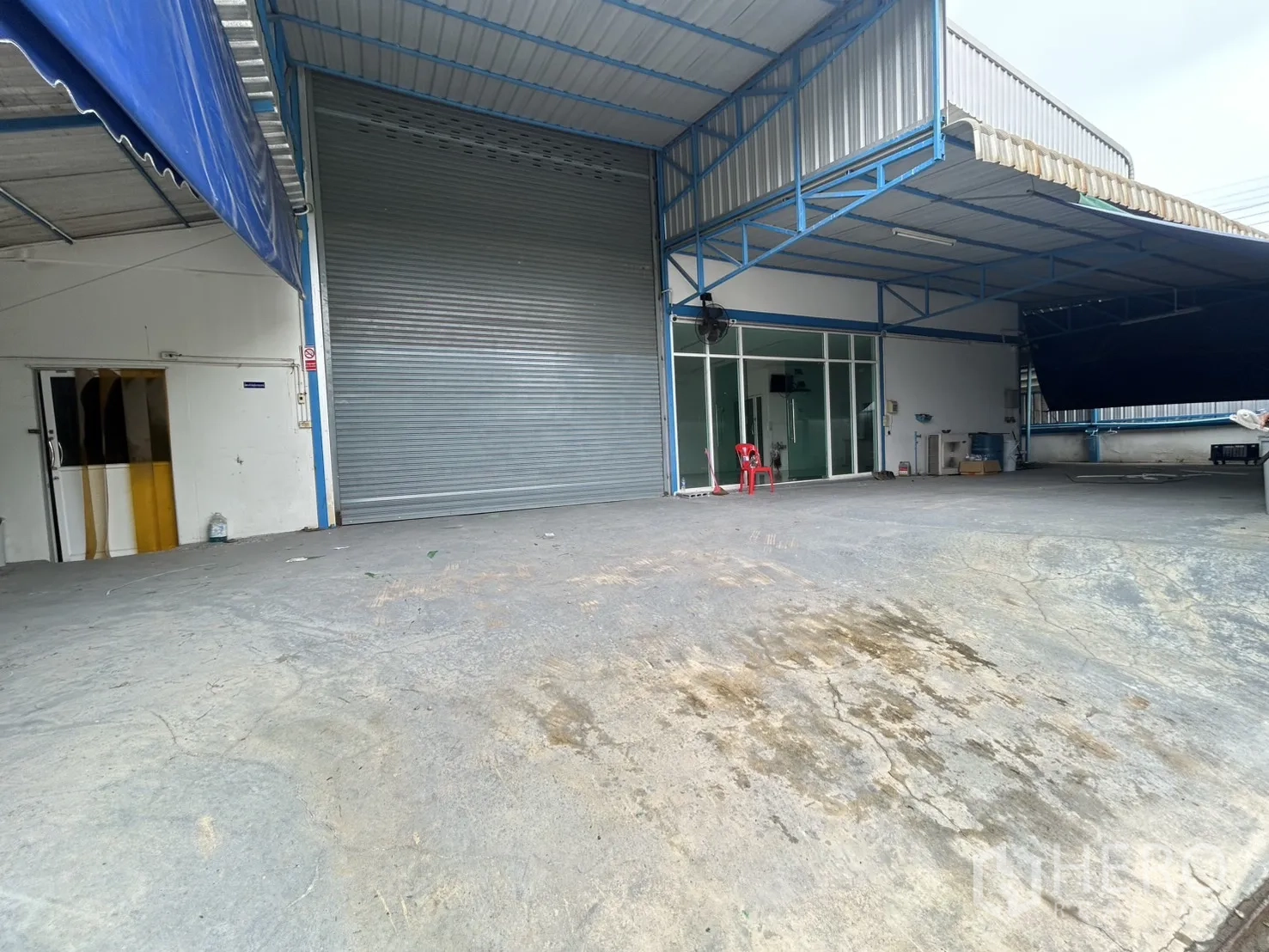 工厂 for rent or sale in Bang Yai, Nonthaburi - 金属雨棚下的装卸院，旁有玻璃办公室和大卷闸门
