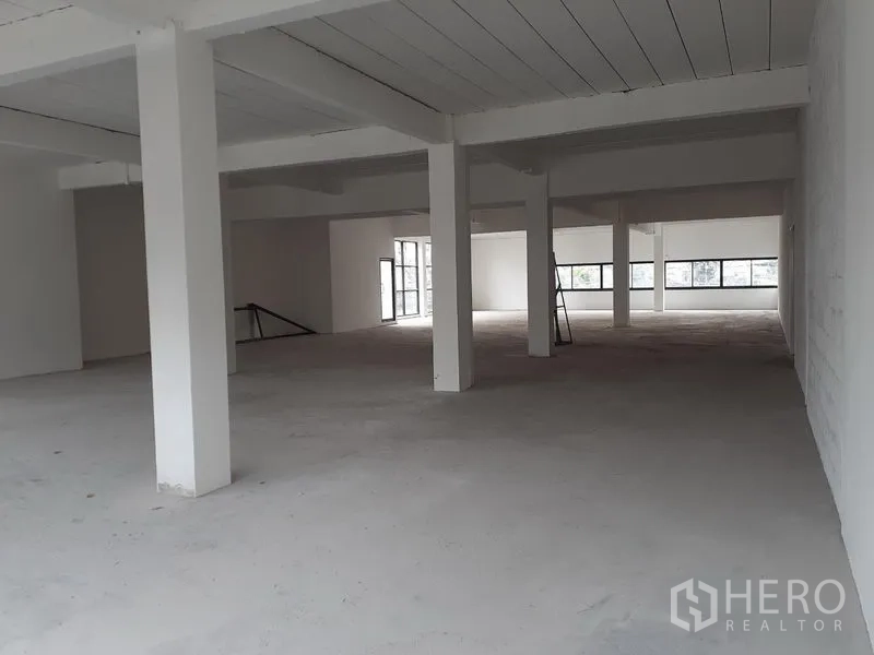 办公空间 出租在Khlong Toei, Bangkok - 未精装的办公室内部，白色立柱、梯子与长条窗，便于二次装修。