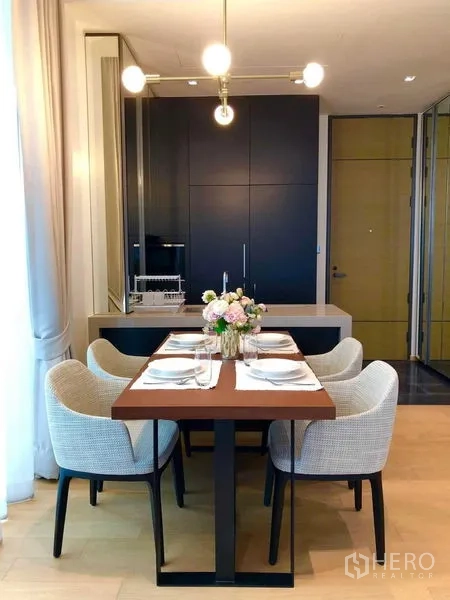 Condominium for rent - Dining space facing a compact kitchen with tall cabinets and the entry door.