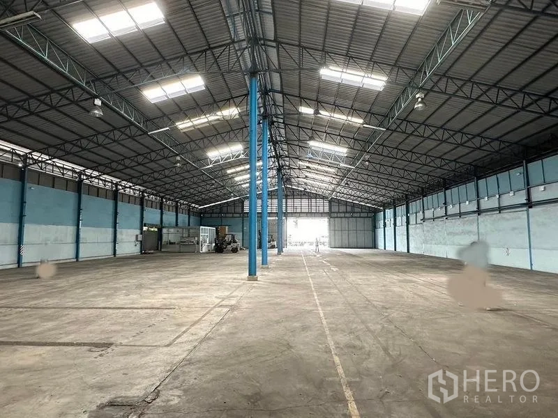 Warehouse for rent in Bang Pa-in, Phra Nakhon Si Ayutthaya - Central aisle view toward large doors, showing generous floor area and lighting.