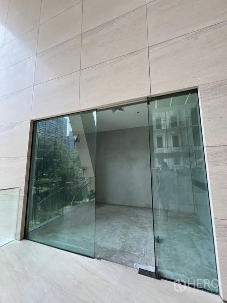 Retail Space for rent in Pathum Wan, Bangkok - Street-facing shop entrance with sliding glass doors and stone-clad exterior near the BTS line.