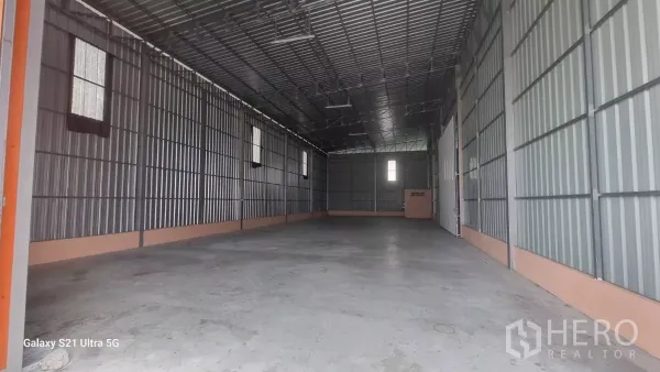 Warehouse for rent in Bueng Kum, Bangkok - Empty 275 sq.m. warehouse with concrete floor, ventilated windows, and a tall gabled roof.