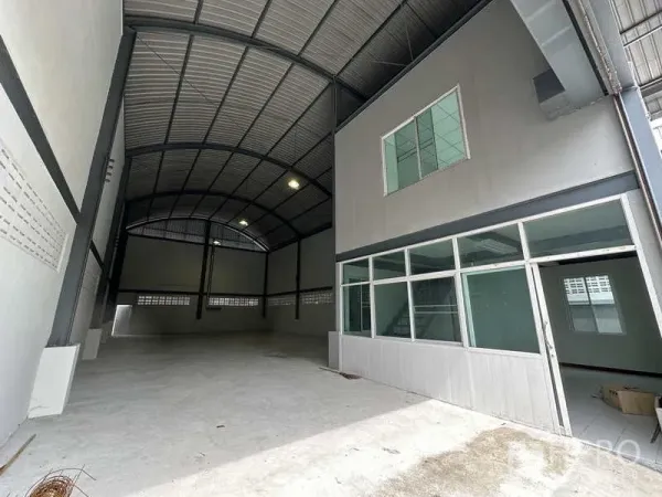 Warehouse for rent in Pak Kret, Nonthaburi - Warehouse entrance showing high-clearance bay and a glass-partitioned front office.