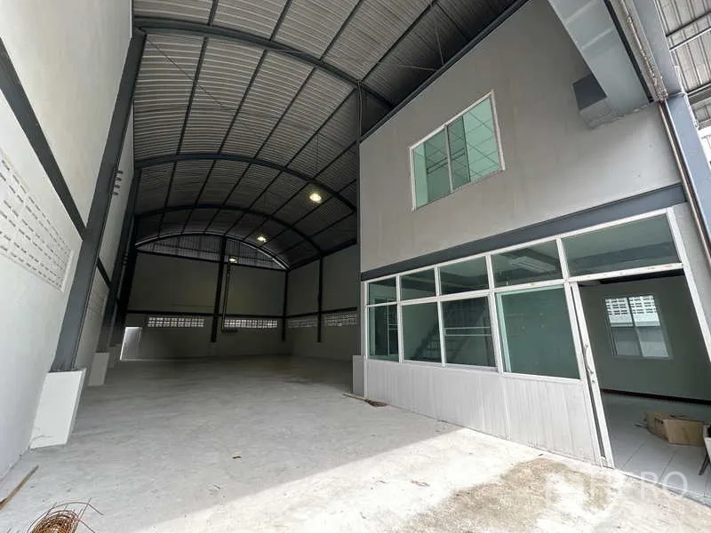 Warehouse for rent in Pak Kret, Nonthaburi - Warehouse entrance showing high-clearance bay and a glass-partitioned front office.