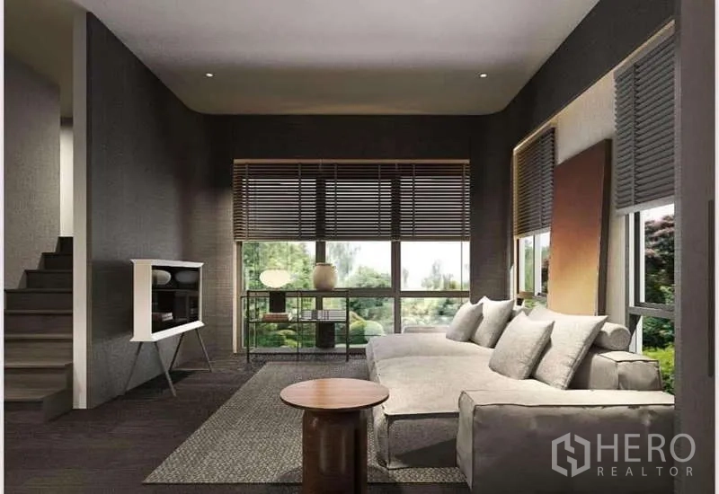 Townhouse for rent in Suan Luang, Bangkok - Cozy second living room with sectional sofa and wide windows looking to the garden.