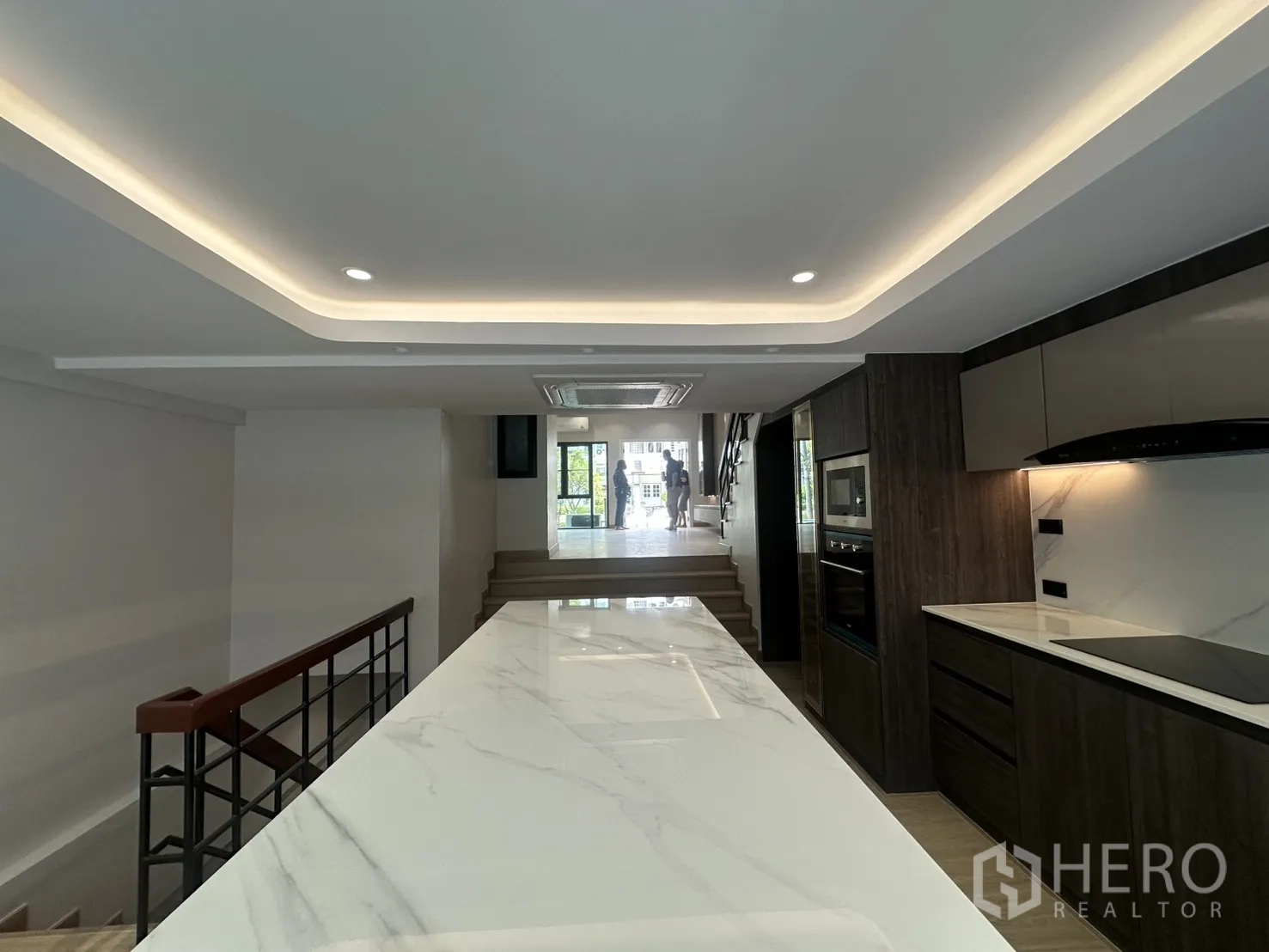 Home Office for rent in Watthana, Bangkok - View over a long marble island toward a split-level living area and stairs.