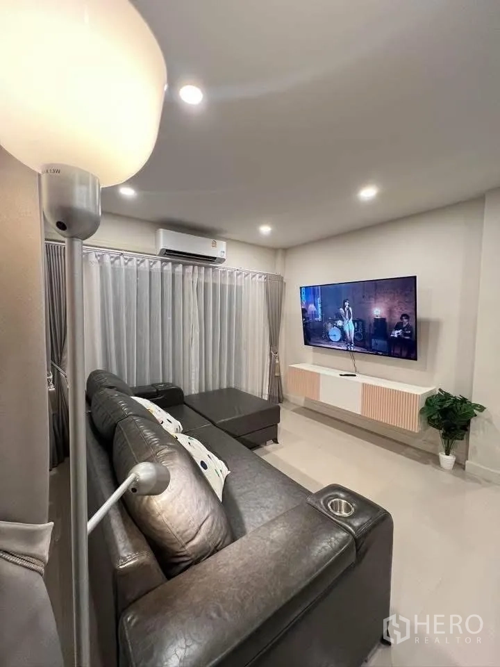 Detached House for rent in Prawet, Bangkok - Living area facing a large wall-mounted TV and media console.