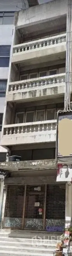 Shophouse for sale in Khlong Toei, Bangkok - Five-storey shophouse exterior with balustrade balconies and closed roller shutter on a Bangkok street.
