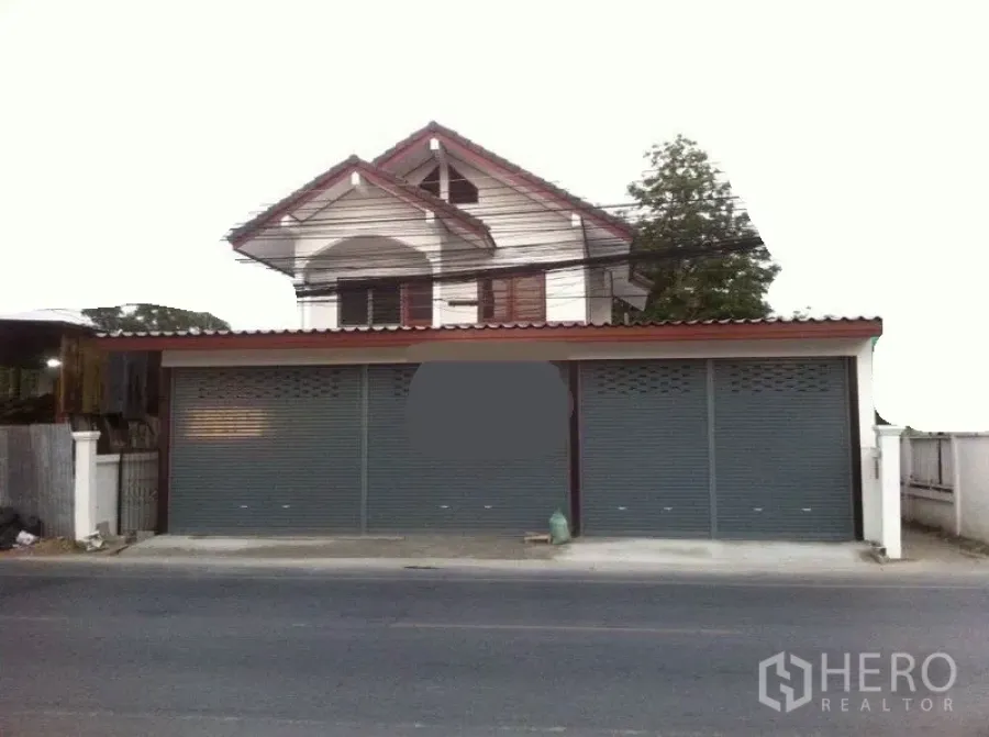 Warehouse for rent in Lam Luk Ka, Pathum Thani - Street-facing warehouse with three metal roller shutters and a gabled upper floor.