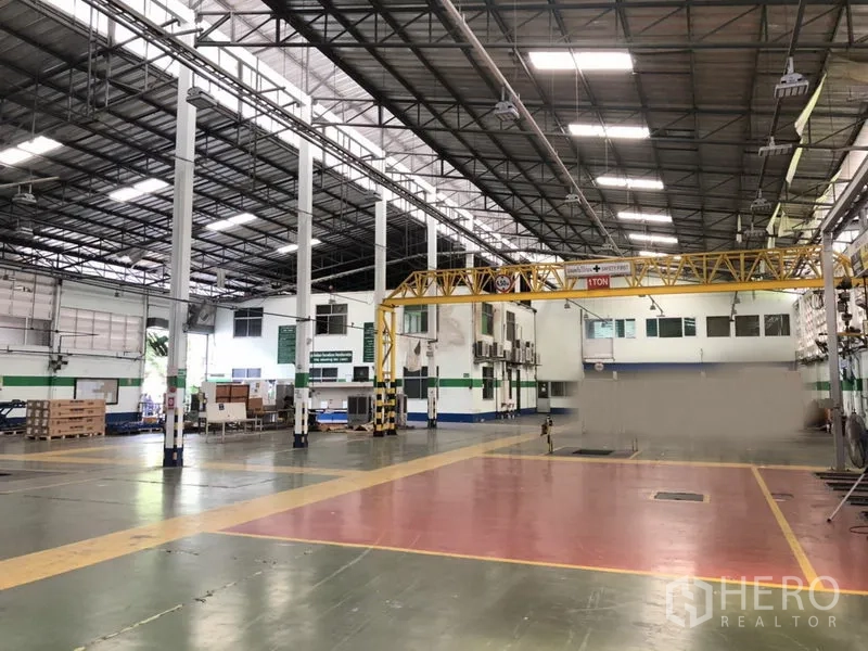 Factory for rent in Lam Luk Ka, Pathum Thani - Large manufacturing area with colored epoxy floor zones, overhead crane and a mezzanine office block.