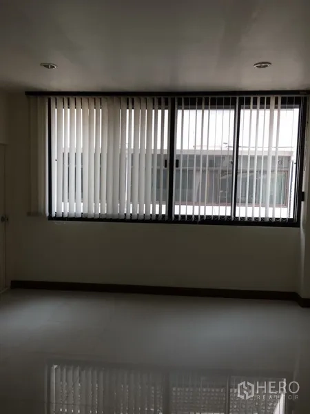Home Office for rent in Bang Rak, Bangkok - Spacious office room with a wide window and vertical blinds bringing in daylight.