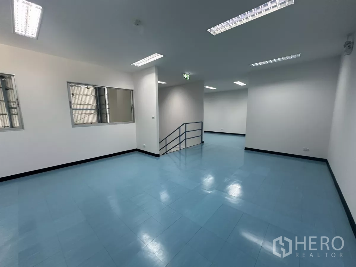 Factory for rent in Bang Phli, Samut Prakan - Long mezzanine corridor-style space with stair rail and ceiling lights.