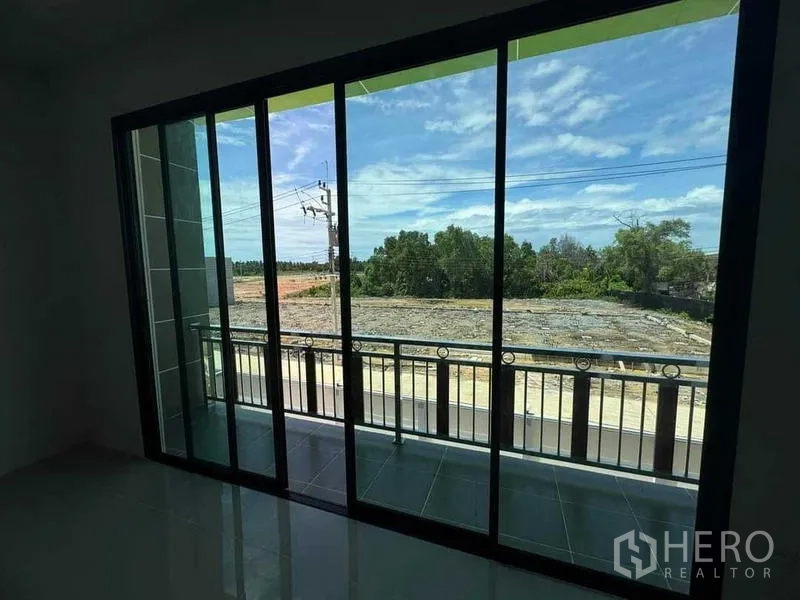 Factory for sale in Samut Sakhon - Upstairs room with full-height sliding glass doors opening to a balcony and open views.