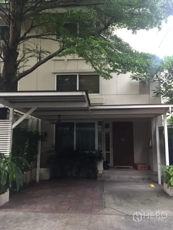 独立式住宅 出租在Watthana, Bangkok - 独栋别墅外立面，带车棚与成熟树木遮荫。