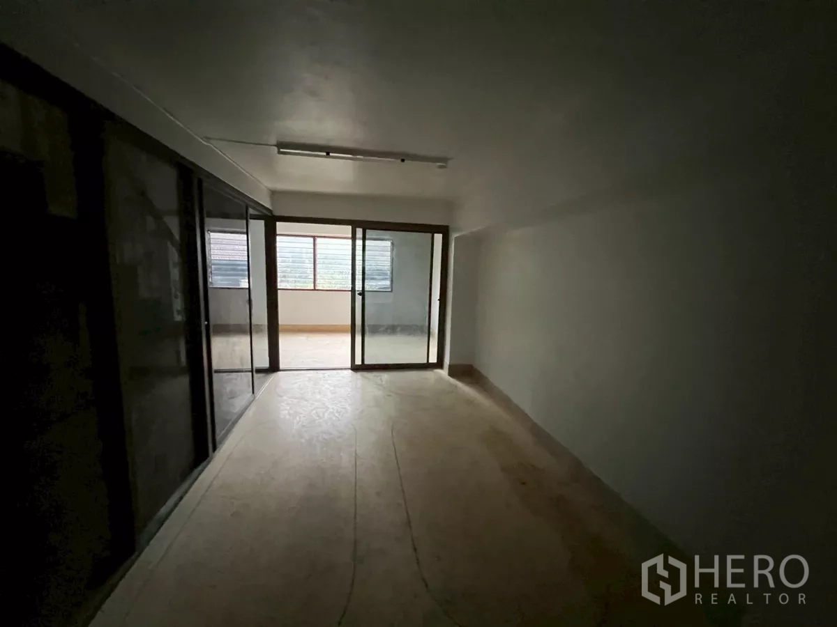 店屋 出租在Khlong Toei, Bangkok - 楼上狭长空间，玻璃推拉门通向封闭式阳台区域。