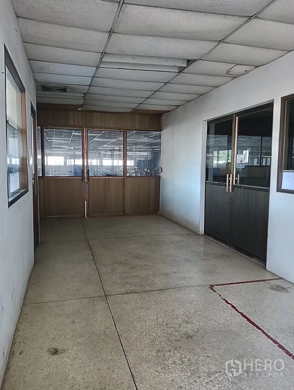 Factory for sale in Lat Krabang, Bangkok - Corridor with glass and wooden partitions leading to the production floor.