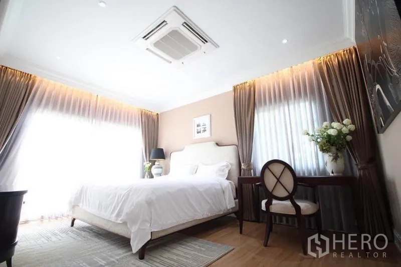 Detached House for rent or sale in Lat Phrao, Bangkok - Sunlit master bedroom with king bed, writing desk and cassette ceiling air conditioner.