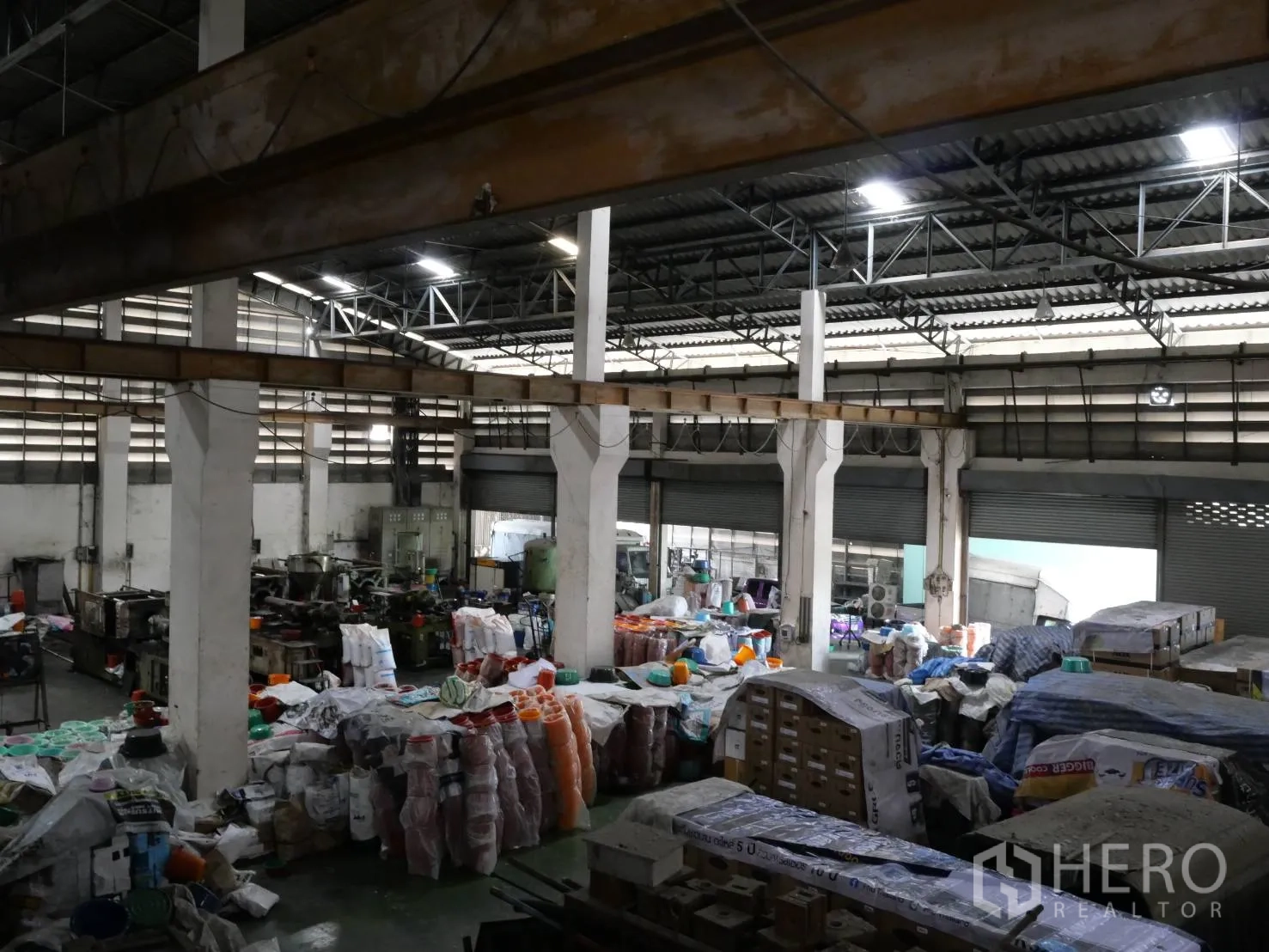 Factory for rent or sale in Bang Khun Thian, Bangkok - Interior view toward several roller shutter loading bays and work zones.