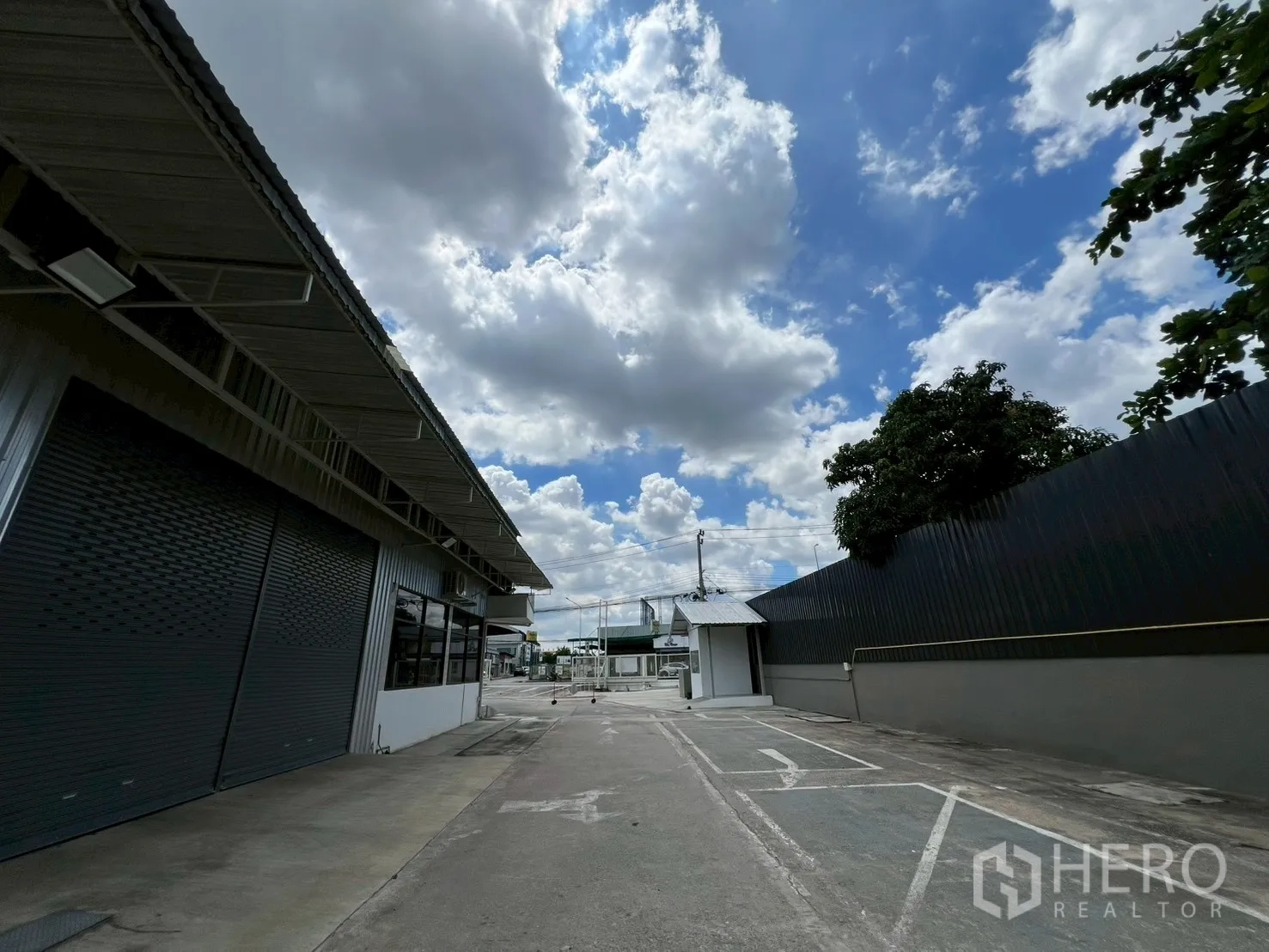 Warehouse for rent in Min Buri, Bangkok - Paved internal driveway of the industrial compound with gatehouse and marked parking.