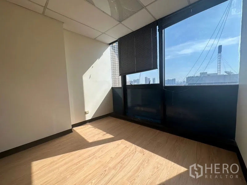 办公空间 出租 - 明亮转角办公室，落地窗配百叶，城市景观与木质地面。