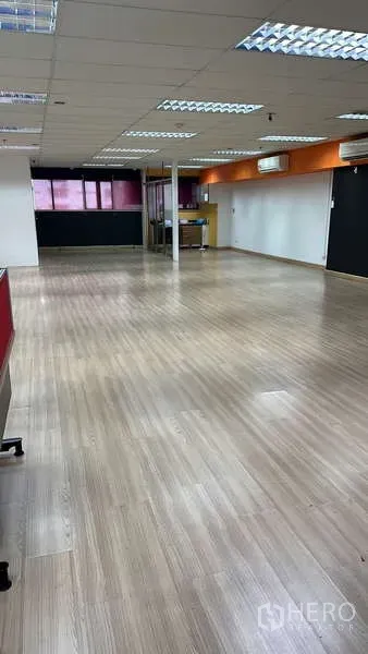 Office Space for rent - Spacious open-plan office with wood laminate flooring and grid ceiling lights.