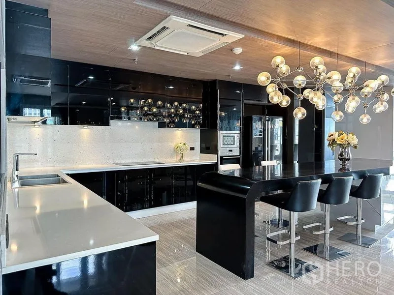 Condominium for rent or sale in Khlong Toei, Bangkok - Gourmet kitchen with glossy black cabinetry, long breakfast island and designer pendant lights.