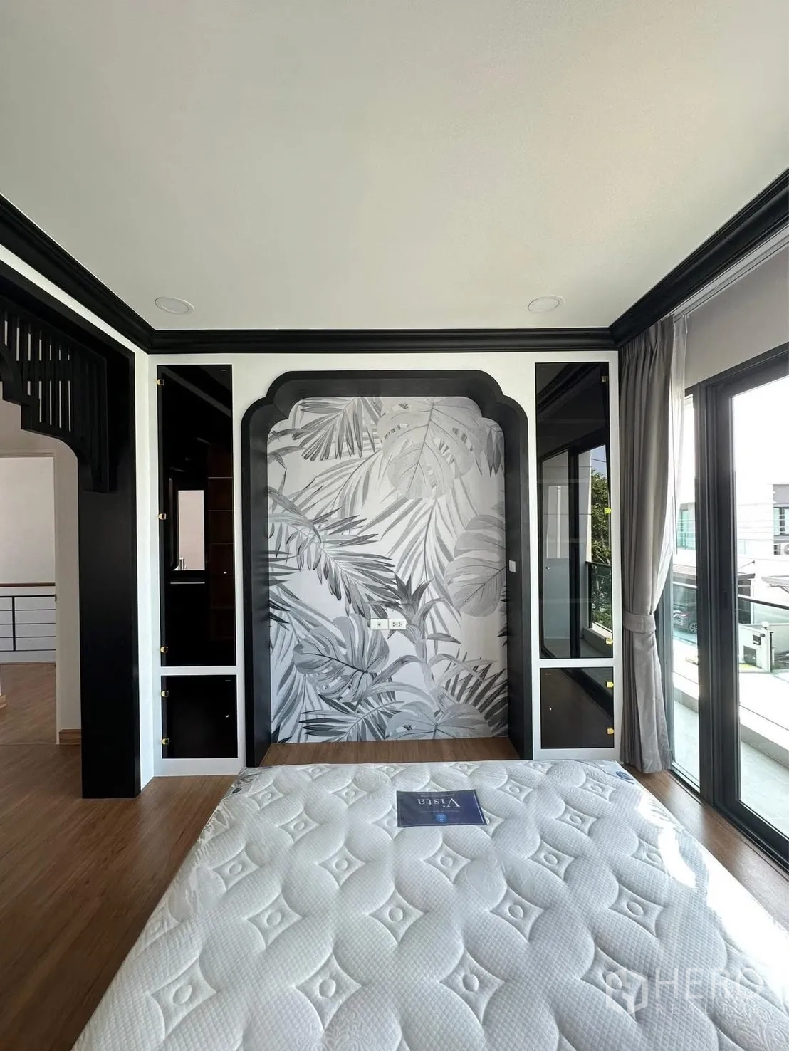 Detached House for rent in Bang Phli, Samut Prakan - Second bedroom with botanical accent wall and sliding doors opening to a balcony.