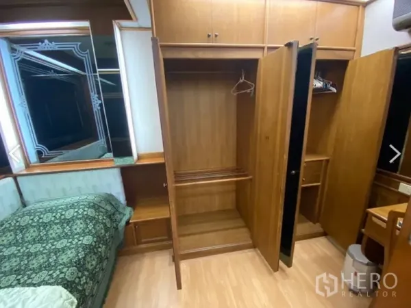 Condominium for sale in Watthana, Bangkok - Bedroom with open built-in wooden wardrobes and a dressing nook at D.S. Tower 2 condo.