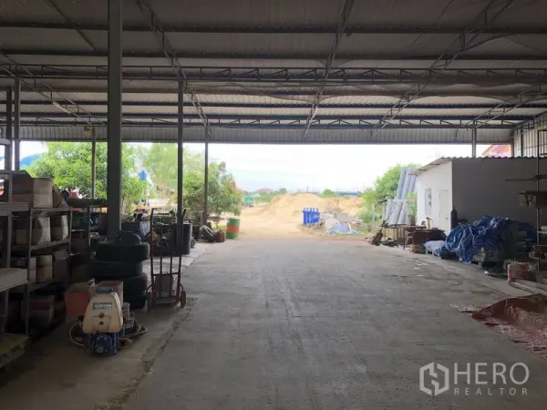 Warehouse for rent in Sai Noi, Nonthaburi - Large covered loading area with steel roof and open access to the rear yard on a concrete surface.