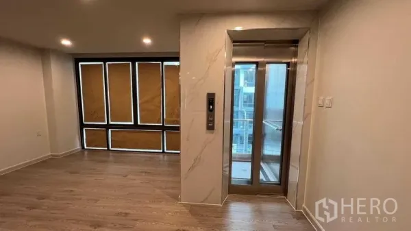 Home Office for rent - Bright interior floor featuring a private glass elevator, wood flooring and wide windows.