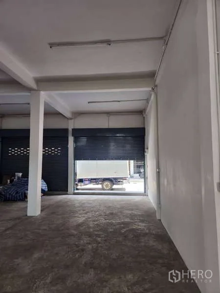 Shophouse for rent in Khlong Toei, Bangkok - Front bay with open roller shutters facing the street, suitable for loading.