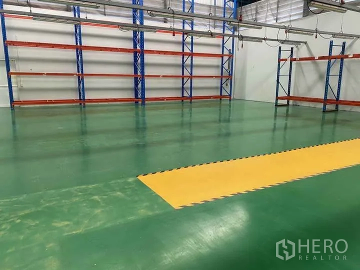 Factory for rent or sale in Bang Yai, Nonthaburi - Warehouse zone with racking and a yellow safety walkway on green epoxy floor.