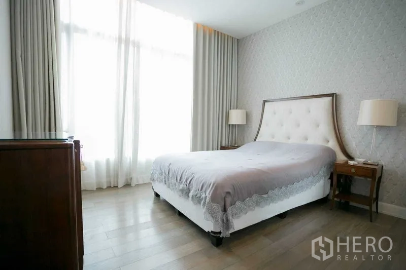 Condominium for rent or sale in Pathum Wan, Bangkok - Bedroom with large windows, sheer curtains and textured wallpaper.
