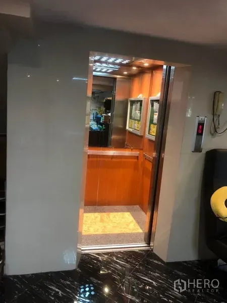 Shophouse for rent in Bang Rak, Bangkok - Open elevator with warm wood-panel cabin inside the shophouse lobby.