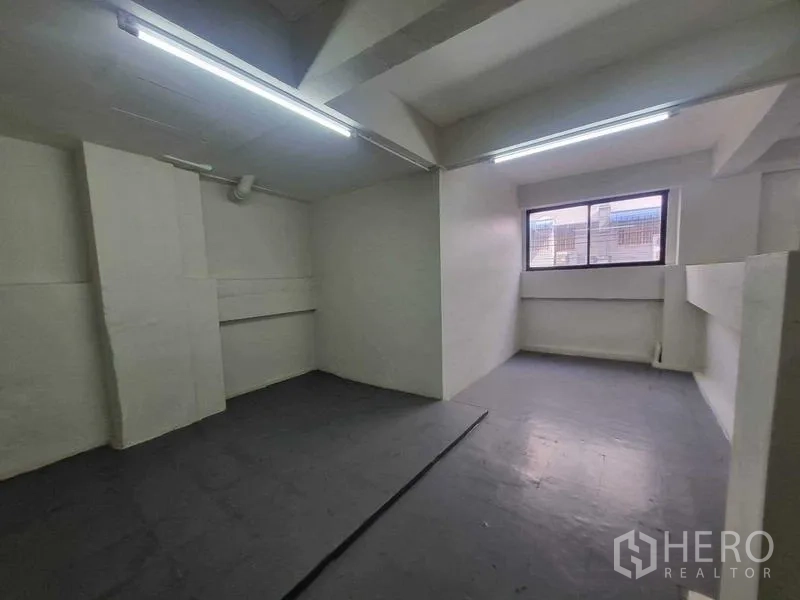Retail Space for rent in Bang Rak, Bangkok - Compact staff room or office with window, white walls and strip lighting.