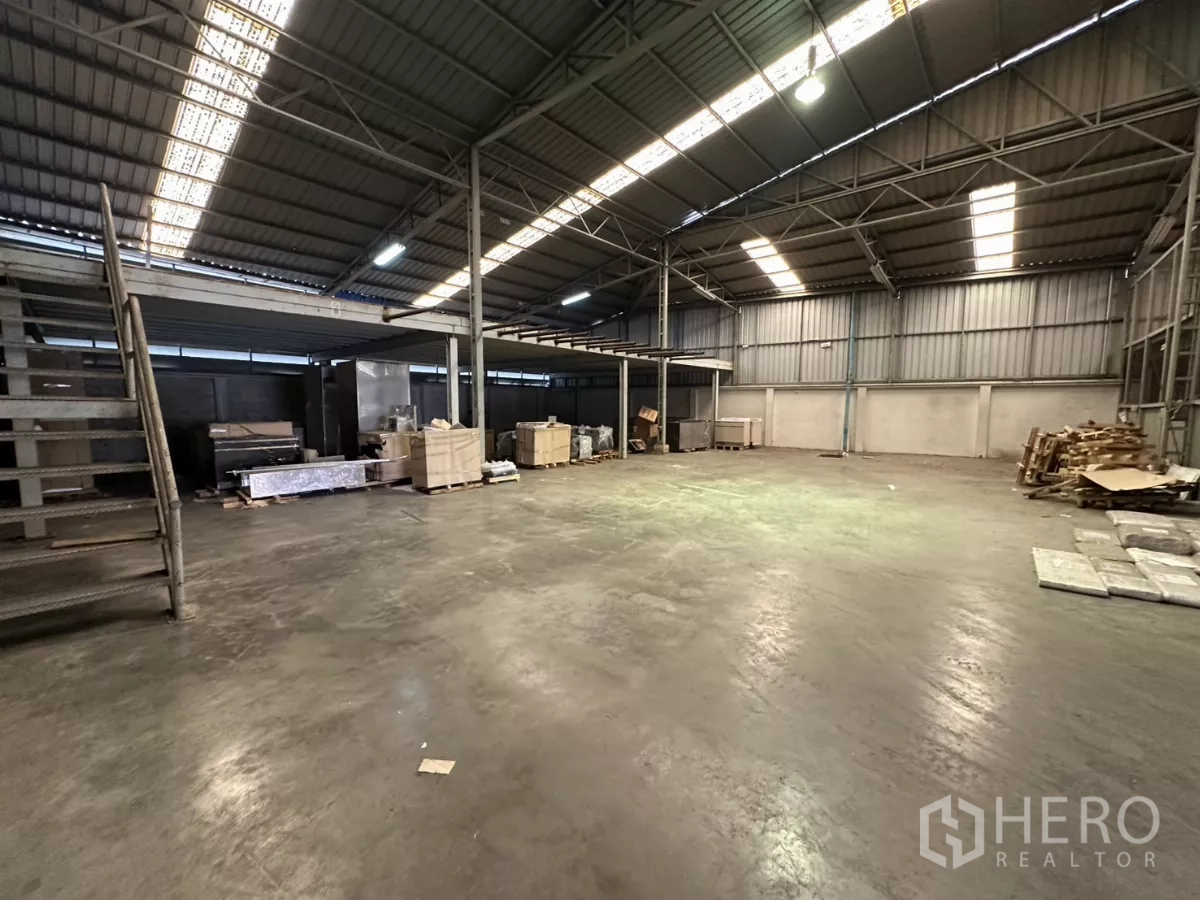 Warehouse for rent in Yan Nawa, Bangkok - Expansive floor area with stairs leading up to a mezzanine platform inside the warehouse.